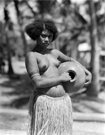 1920s 1930s SERIOUS UNSMILING PORTRAIT TOPLESS PAPUAN GIRL NATIVE IN GRASS SKIRT NEW GUINEA Foto de stock - Con derechos protegidos, Código: 846-02796390