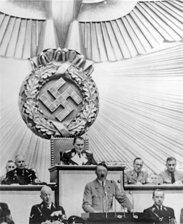 ANNÉES 1930 ADOLPH HITLER PODIUM S'EXPRIMANT SOUS UNE GRANDE CROIX GAMMÉE AU REICHSTAG Photographie de stock - Rights-Managed, Code: 846-02796478