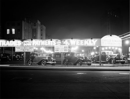 1920s 1930s NEW AND USED CAR LOT NIGHT NEW YORK CITY GREENWICH VILLAGE AUTO AUTOMOTIVE AUTOMOBILE SALES SIXTH AVENUE AND WAVERLY STREET Stock Photo - Rights-Managed, Code: 846-02796507