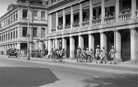 simsearch:846-02796405,k - ANNÉES 1930 ANNÉES 1920 RUE SCÈNE CHINE HONG KONG RICKSHAW GROUPE DE SOLDATS INDIENS MARCHANT PAR LE FUSIL Photographie de stock - Rights-Managed, Code: 846-02796541