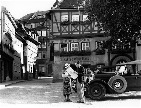 1930s TOURIST COUPLE BY CAR LOOKING AT MAP IN FRONT OF EISENACH LUTHERHAUS 1563 WHERE LUTHER LIVED WHILE ATTENDING SCHOOL Stock Photo - Rights-Managed, Code: 846-02796665