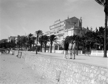 retro french - ANNÉES 1920 2 FEMMES, 1 HOMME STAND TALKING ON FRENCH RIVIERA CANNES DE PROMENADE MODE MÉDITERRANÉE RETRO VINTAGE Photographie de stock - Rights-Managed, Code: 846-02796666