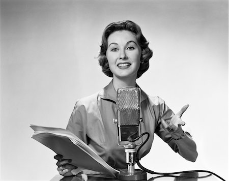 radio broadcasting - 1950s 1960s WOMAN ANNOUNCER READING FROM PAPERS SPEAKING INTO MICROPHONE Stock Photo - Rights-Managed, Code: 846-02796670