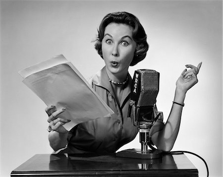 exaggerating - 1950s WOMAN TALKING INTO RADIO MICROPHONE HOLDING PAPERS EXAGGERATED FACIAL EXPRESSION Stock Photo - Rights-Managed, Code: 846-02796673