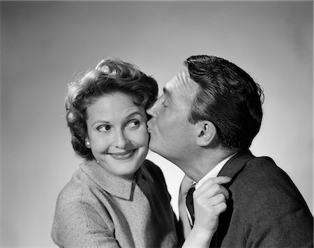 1950s COUPLE MAN KISSING UNCERTAIN WOMAN ON THE CHEEK Stock Photo - Rights-Managed, Code: 846-02796718
