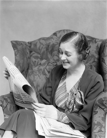 simsearch:846-02792809,k - 1930s WOMAN IN STRIPED DRESS SITTING IN CHAIR WITH HAPPY EXPRESSION READING NEWSPAPER Stock Photo - Rights-Managed, Code: 846-02796725