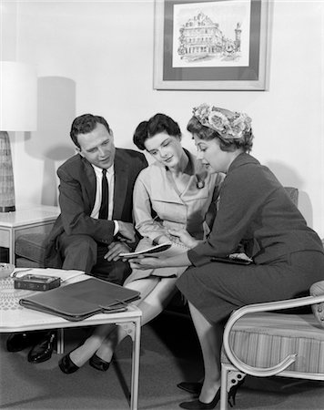 simsearch:846-02796796,k - 1950s COUPLE MAN WOMAN IN HOME VISITED BY SALESWOMAN SEATED HOLDING SHOWING SALES LITERATURE Fotografie stock - Rights-Managed, Codice: 846-02796800