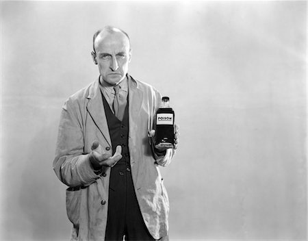 ANNÉES 1930 DOUR MAN IN LAB COAT HOLDING BOUTEILLE DE POISON Photographie de stock - Rights-Managed, Code: 846-02796829