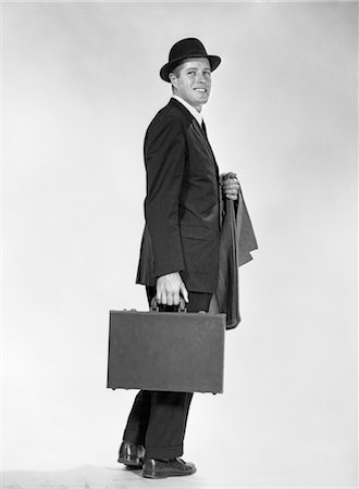 simsearch:846-02796007,k - 1960s PROFILE FULL FIGURE BUSINESSMAN BUSINESS SUIT TIE OVERCOAT ON ARM HOLDING BRIEFCASE SMILING Foto de stock - Direito Controlado, Número: 846-02796834