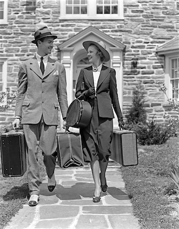 simsearch:846-02792921,k - ANNÉES 1930 1940 SOURIANT COUPLE LAISSANT ACCUEIL TRANSPORTANT DES BAGAGES Photographie de stock - Rights-Managed, Code: 846-02796928