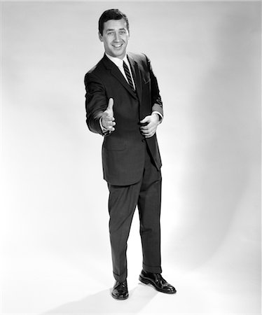 1960s SMILING FULL LENGTH PORTRAIT MAN BUSINESS MAN WITH HAND EXTENDED IN GREETING FOR HANDSHAKE Foto de stock - Con derechos protegidos, Código: 846-02796964