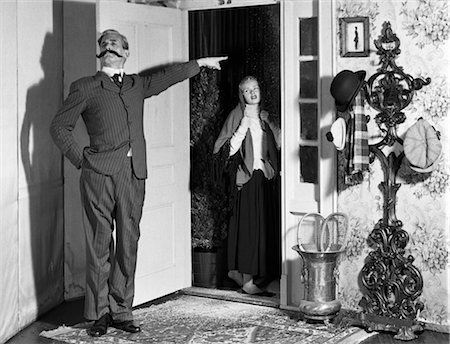 scusarsi - 1960s SET-UP OF VICTORIAN MAN WITH HANDLEBAR MUSTACHE BANISHING WOMAN IN DOORWAY Fotografie stock - Rights-Managed, Codice: 846-02796989