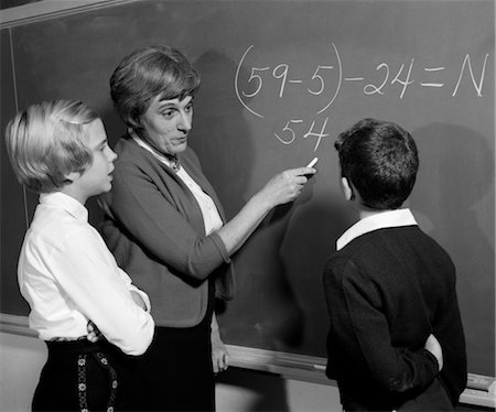 1960s TEACHER AT BLACKBOARD WITH MALE & FEMALE STUDENT EXPLAINING MATH PROBLEM Stock Photo - Rights-Managed, Code: 846-02797027