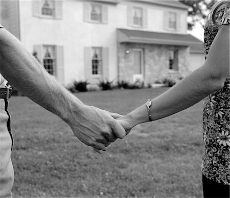 simsearch:846-02792735,k - 1970s CLOSE-UP OF COUPLE HOLDING HANDS WITH NEW HOME IN BACKGROUND Stock Photo - Rights-Managed, Code: 846-02797092