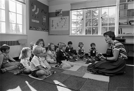 simsearch:846-02794249,k - 1980s GRADE SCHOOL TEACHER SITTING ON FLOOR WITH STUDENTS PLAYING GUITAR & SINGING Stock Photo - Rights-Managed, Code: 846-02797159