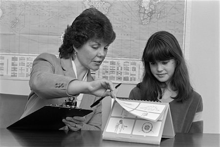 elementary school 1980s - 1980s GRADE SCHOOL TEACHER HOLDING CLIPBOARD TESTING FEMALE STUDENT Stock Photo - Rights-Managed, Code: 846-02797167