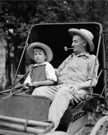 1930s FARM BOY & GRANDFATHER IN OVERALLS & STRAW HATS SITTING IN SMALL BUGGY Foto de stock - Con derechos protegidos, Código: 846-02797258