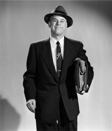 simsearch:846-02796796,k - 1950s 3 4 LENGTH PORTRAIT SMILING MAN SALESMAN BUSINESSMAN HOLDING BRIEFCASE WEARING HAT Stock Photo - Rights-Managed, Code: 846-02797287