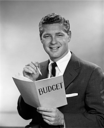 simsearch:846-02797280,k - 1950s MAN IN BUSINESS SUIT HOLDING PENCIL AND BUDGET BOOK Stock Photo - Rights-Managed, Code: 846-02797281