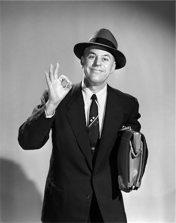 1950s MAN BUSINESSMAN SALESMAN MAKING OKAY SIGN WITH ONE HAND CARRYING BRIEFCASE WEARING HAT Foto de stock - Con derechos protegidos, Código: 846-02797292