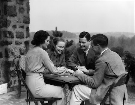 playing cards table - 1930s TWO COUPLES MEN WOMEN PLAY PLAYING CARDS AT TABLE ON OUTDOOR PATIO SOCIAL CARD GAME BRIDGE RETRO VINTAGE LIFESTYLE UPSCALE Stock Photo - Rights-Managed, Code: 846-02797377