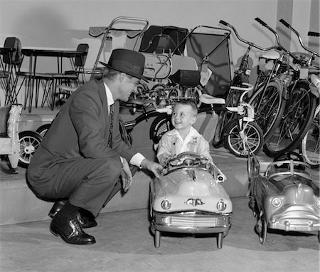 1950s FATHER IN TOY STORE WITH SON DRIVING TOY CONVERTIBLE Foto de stock - Con derechos protegidos, Código: 846-02797429