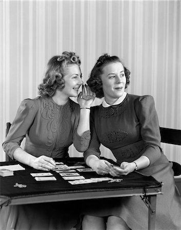 photo of card playing woman - 1940s TWO GIRLS SITTING AT CARD TABLE PLAYING CARDS AND WHISPERING Stock Photo - Rights-Managed, Code: 846-02797461