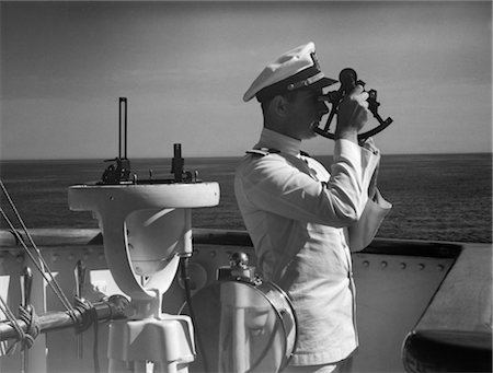 ANNÉES 1940 HOMME MARIN CAPITAINE AGENT À L'AIDE DE SEXTANT SUR LE PONT DU NAVIRE NAVIGATION LATITUDE LONGITUDE CALCUL MARINE Photographie de stock - Rights-Managed, Code: 846-02797556