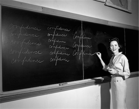 ENSEIGNANT DES ANNÉES 1950 EN FACE D'ÉCRITURE EN CLASSE CONFIANCE ON BLACKBOARD Photographie de stock - Rights-Managed, Code: 846-02797559