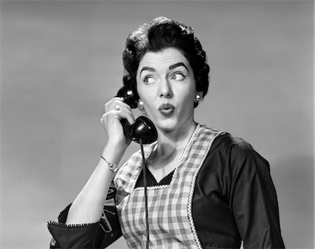1950s WOMAN WEARING APRON TALKING ON TELEPHONE WITH EXAGGERATED SURPRISED EXPRESSION Stock Photo - Rights-Managed, Code: 846-02797571