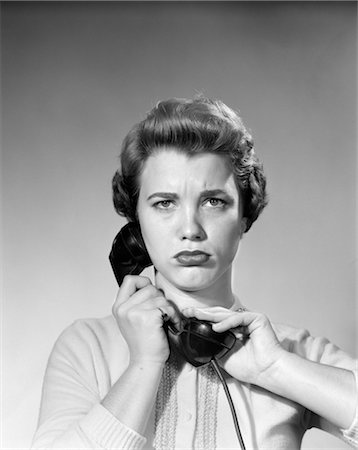 people annoying by phone - 1950s WOMAN HOLDING RECEIVER HAND OVER RECEIVER LOOKING AT CAMERA WITH ANNOYED ANGRY EXPRESSION Stock Photo - Rights-Managed, Code: 846-02797604