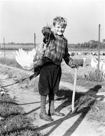 1940s BOY IN PLAID JACKET AND KNICKERS SMILING HOLDING LIVE TURKEY OVER SHOULDER AND AXE Stock Photo - Rights-Managed, Code: 846-02797660