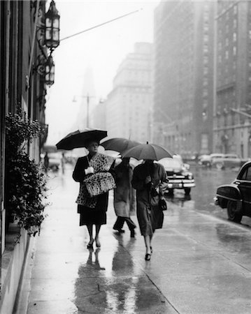 1940s 1950s FASHIONABLE WOMAN LEOPARD MUFF STOLE WALKING DOWN RAINY CITY STREET Foto de stock - Con derechos protegidos, Código: 846-02797711