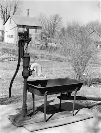 POMPE À EAU DES ANNÉES 1940 AVEC AUGET EN ZONE AGRICOLE RURALE Photographie de stock - Rights-Managed, Code: 846-02797756