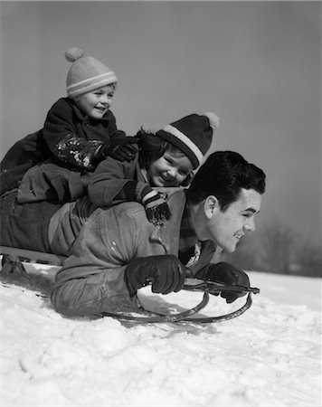 1930s FATHER AND CHILDREN PILED ON SLED GOING DOWN HILL IN SNOW LAUGHING Foto de stock - Con derechos protegidos, Código: 846-02797805