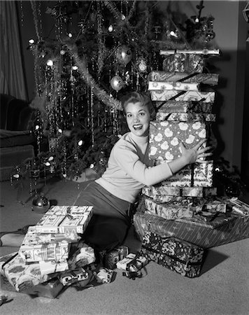 retro christmas images - 1950s WOMAN SITTING ON FLOOR IN FRONT OF XMAS TREE HOLDING PACKAGES Stock Photo - Rights-Managed, Code: 846-02797885