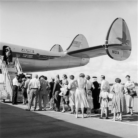 passenger airplane - 1950s TAIL OF COMMERCIAL AVIATION AIRPLANE ON TARMAC WITH PASSENGERS IN LINE WAITING TO BOARD Stock Photo - Rights-Managed, Code: 846-02791720