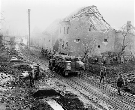 ANNÉES 1940 GUERRE MONDIALE CHAR AMÉRICAIN ARMOR ET L'INFANTERIE SE DÉPLAÇANT DANS UNE GUERRE DE RUINES DE DÉVASTATION ENCORE FUMER ALLEMAND VILLE Photographie de stock - Rights-Managed, Code: 846-02791736