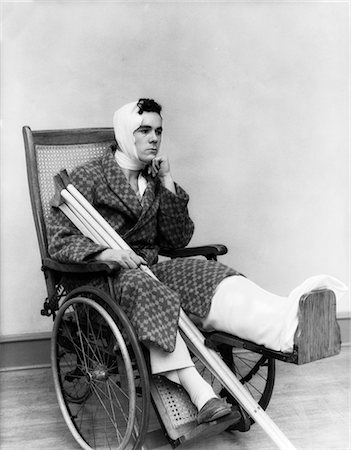 d'une personne - ANNÉES 1930 HOMME EN CHAISE ROULANTE JAMBE BANDAGE CULASSE COU BÉQUILLES HURT DÉPRIMÉS NON VALIDE BRISÉ DOULEUR BLESSURES Photographie de stock - Rights-Managed, Code: 846-02791742