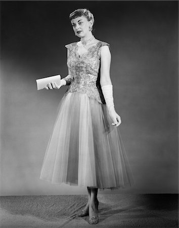 fashion 1940s - 1950s WOMAN STANDING INSIDE WEARING FORMAL EVENING DRESS HOLDING POCKETBOOK Stock Photo - Rights-Managed, Code: 846-02791883