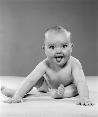 1950s PORTRAIT OF BABY SITTING AND STICKING TONGUE OUT INDOOR Stock Photo - Rights-Managed, Code: 846-02791890