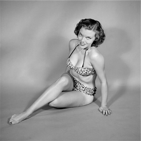 1950s SMILING SEATED WOMAN BATHING BEAUTY PINUP IN LEOPARD SKIN SPOTTED BIKINI LOOKING AT CAMERA Stock Photo - Rights-Managed, Code: 846-02792033