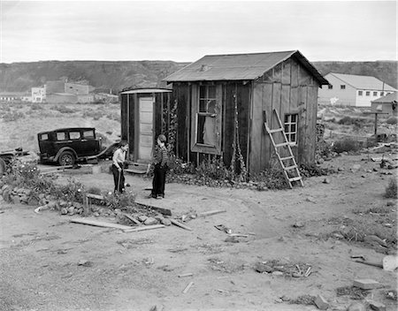 1930s POVERTY SCENE WITH 2 BOYS PLAYING IN FRONT OF SHACK DURING THE DEPRESSION Stock Photo - Rights-Managed, Code: 846-02792054