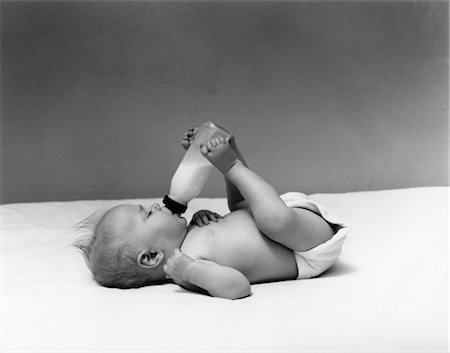 1940s BABY PRONE DRINKING FROM MILK BOTTLE HELD WITH FEET Stock Photo - Rights-Managed, Code: 846-02792097