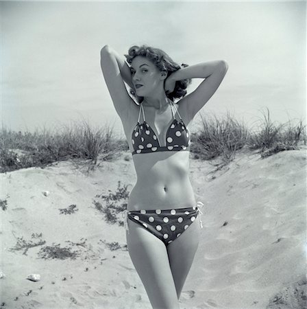 polka dot - 1950s BRUNETTE BATHING BEAUTY IN POLKA DOT BIKINI STANDING IN SAND WITH HANDS BEHIND HEAD Stock Photo - Rights-Managed, Code: 846-02792136