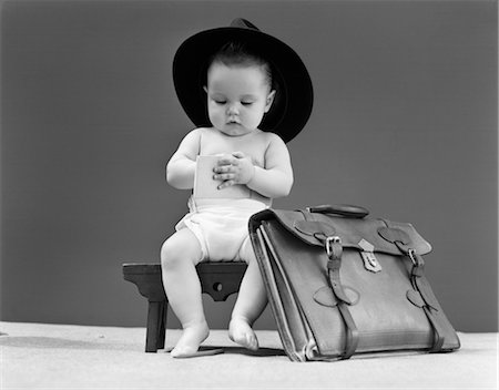 1940s BABY IN FEDORA SEATED ON STOOL WRITING IN NOTEBOOK WITH BRIEFCASE AT SIDE Stock Photo - Rights-Managed, Code: 846-02792132