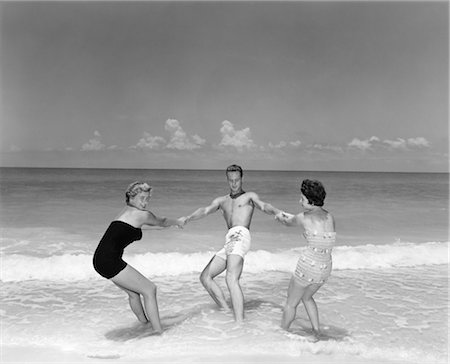 retro woman flirting - 1950s MAN AND TWO WOMEN FROLICKING IN BEACH SURF Stock Photo - Rights-Managed, Code: 846-02792169