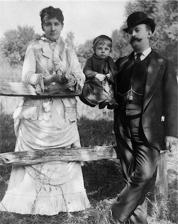 TURN OF THE CENTURY MAN & WOMAN STANDING AT POST & RAIL FENCE WITH CHILD SITTING ON RAIL Stock Photo - Rights-Managed, Code: 846-02792321