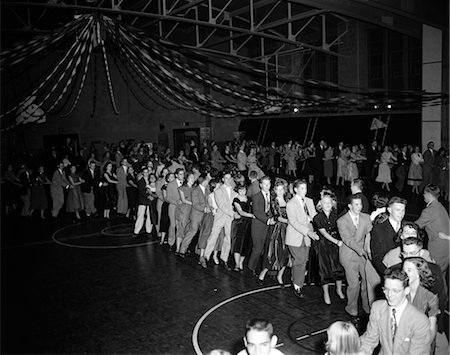 people party retro not outdoors not indoors not illustration - 1950s HIGH SCHOOL DANCE WITH LARGE CROWD OF TEEN COUPLES IN A CONGA LINE SNAKING THROUGH THE GYMNASIUM Stock Photo - Rights-Managed, Code: 846-02792351