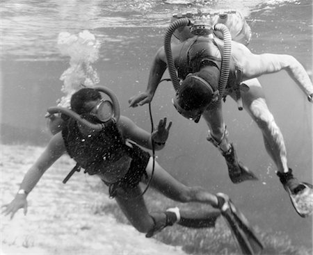 1960s PAIR OF DIVERS WITH TANKS & MASKS IN SHALLOW WATER NEAR GRASSY AREA OF OCEAN FLOOR Stock Photo - Rights-Managed, Code: 846-02792353